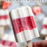 Pinterest Pin with text 'Healthy Parfait Breakfast Popsicles', image of close up of a hand holding a red and white layered popsicle.