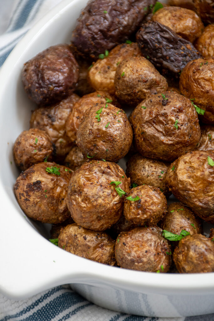 Close up of a couple of shiny crispy baby potatoes made in the air fryer.