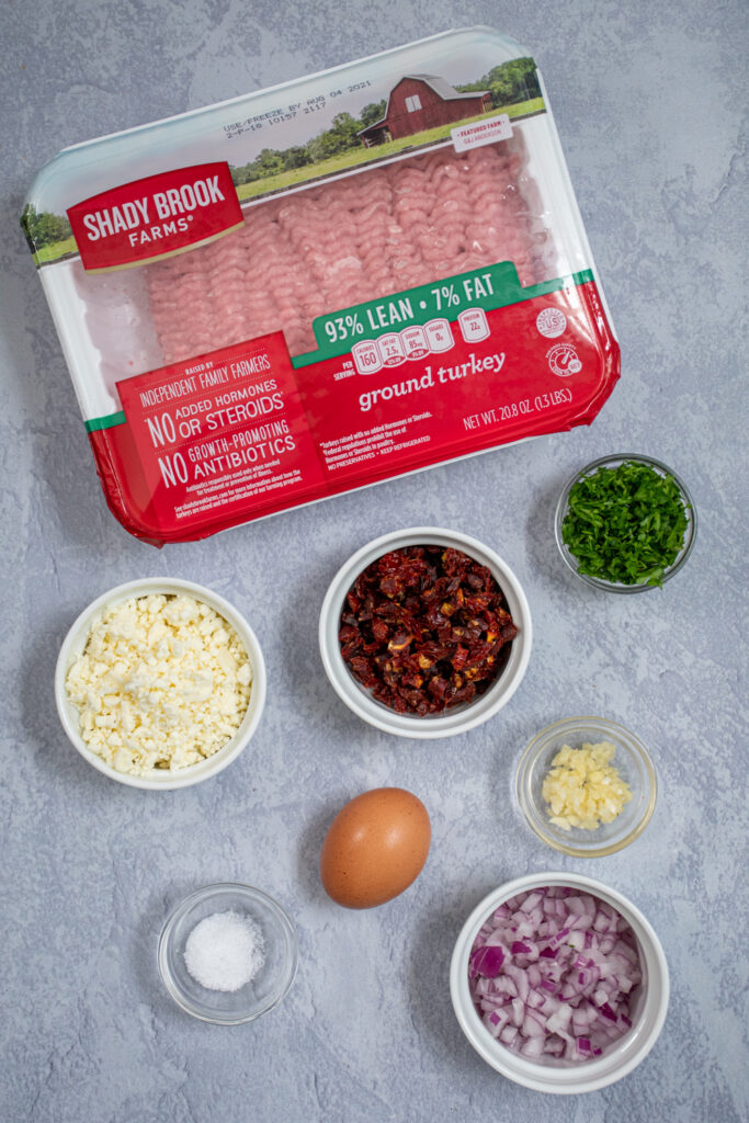 Flatlay of ingredients on a tabletop to make mediterranean turkey burgers with feta.