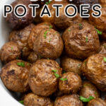 Pinterest pin with text 'Air Fryer Baby Potatoes', image showing a white serving dish filled with salty baby potatoes.