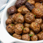 Pinterest pin with text 'Air Fryer Baby Potatoes', image showing a white serving dish filled with salty baby potatoes.