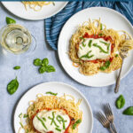 Pinterest Pin with text 'Oven Baked Chicken Parmesan' image of a plate filled with spaghetti topped with a chicken parm.