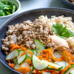 Pinterest Pin with text 'Banh Mi Bowls' with image of bowls of ground pork, brown rice, and quick pickled vegetables.