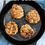 Pinterest Pin with text 'Mediterranean Turkey Burgers' image of a black skillet with four just cooked turkey burgers.