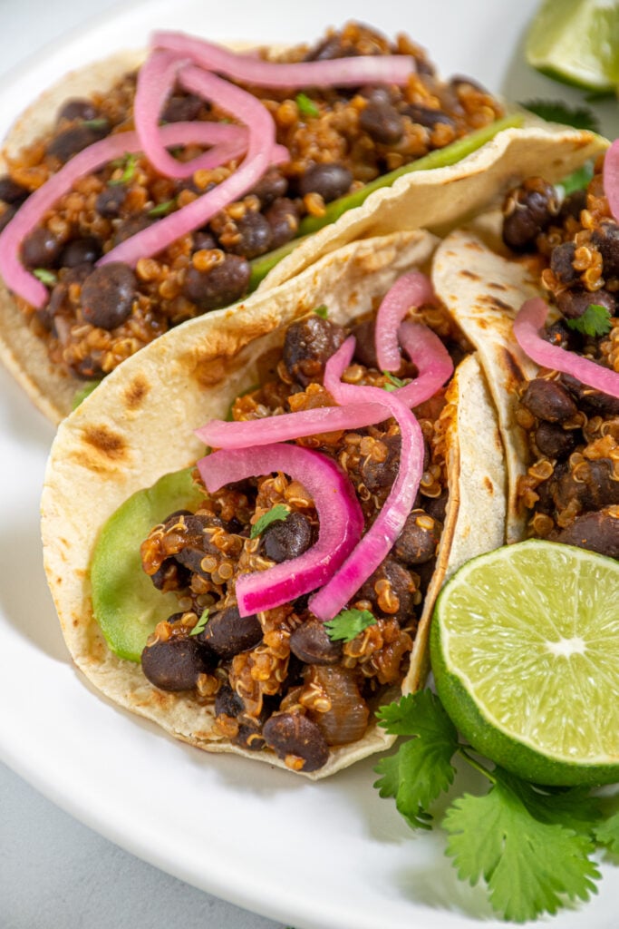 close up of black bean quinoa taco meat in a corn tortilla showing the saucy quinoa and black beans.