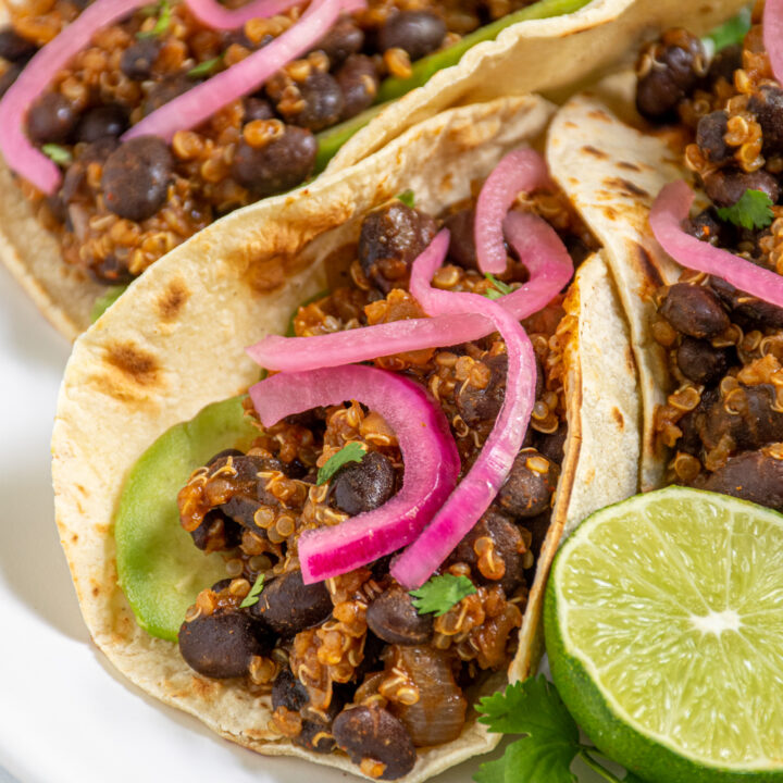 close up of black bean quinoa taco meat in a corn tortilla showing the saucy quinoa and black beans.