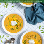 Pinterest Pin with text 'Slow Cooker Pumpkin Chili', image of bowls of yellow pumpkin chili topped with green onions, and sour cream.