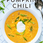 Pinterest Pin with text 'Crockpot Pumpkin Chili', image of bowl of yellow pumpkin chili topped with green onions, and sour cream.