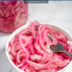 Pinterest Pin with text 'Quick Pickled Red Onions' with image of white bowl of red quick pickled onions with a fork.