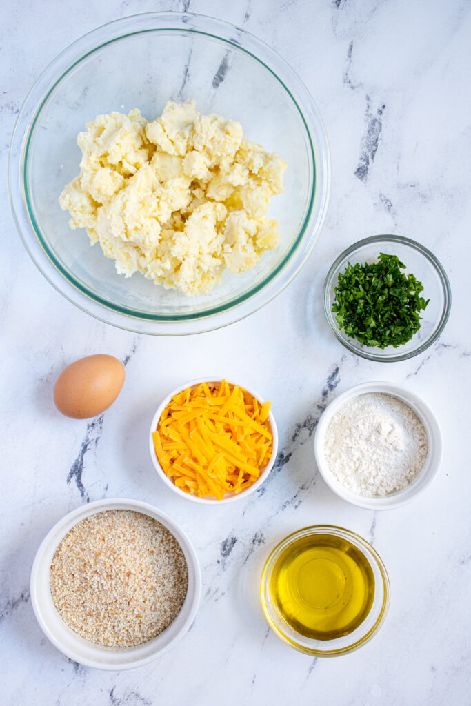 Ingredients for leftover mashed potato cakes laid out on a tabletop.