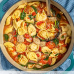 Pinterest Pin with text "Tortellini Soup with Chicken Sausage", image of a pot of tortellini soup.