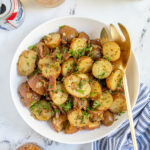 Pinterest Pin with text 'Warm German Potato Salad', image of a white bowl filled with German potato salad with bacon and fresh parsley.