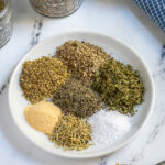 Pinterest Pin with text 'Homemade Italian Seasoning',image of a small plate with Italian seasoning ingredients.
