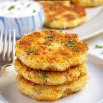 Pinterest Pin with text 'Leftover Mashed Potato Cakes', image showing golden brown leftover mashed potato cakes on a platter with fresh parsley.