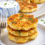 Pinterest Pin with text 'Leftover Mashed Potato Cakes', image showing golden brown leftover mashed potato cakes on a platter with fresh parsley.