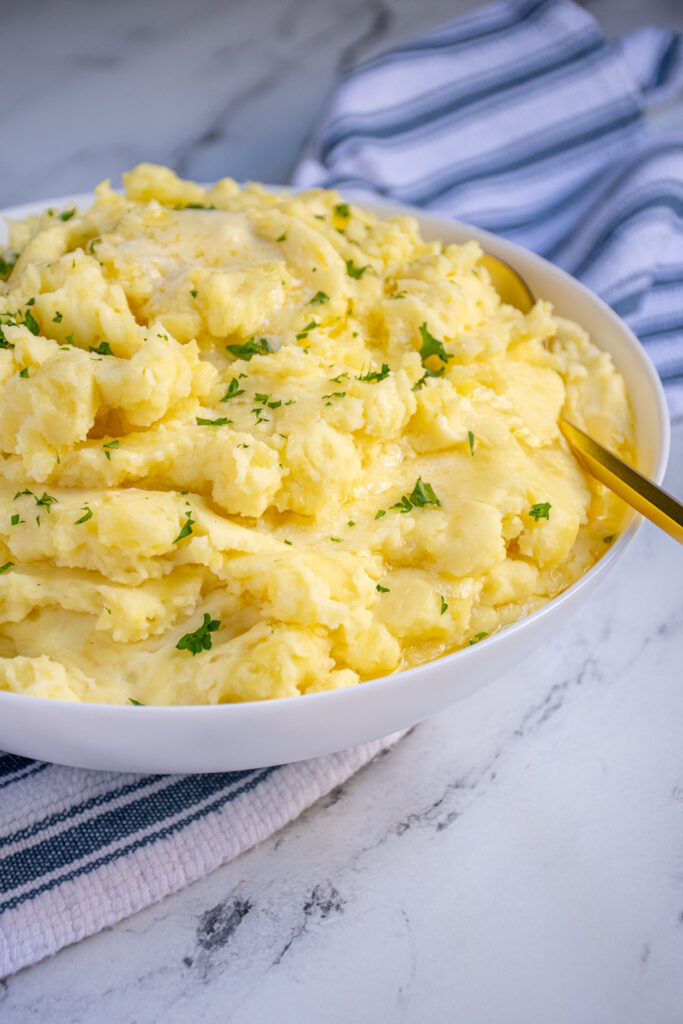 Side view of a bowl of fluffy and creamy mashed potatoes.