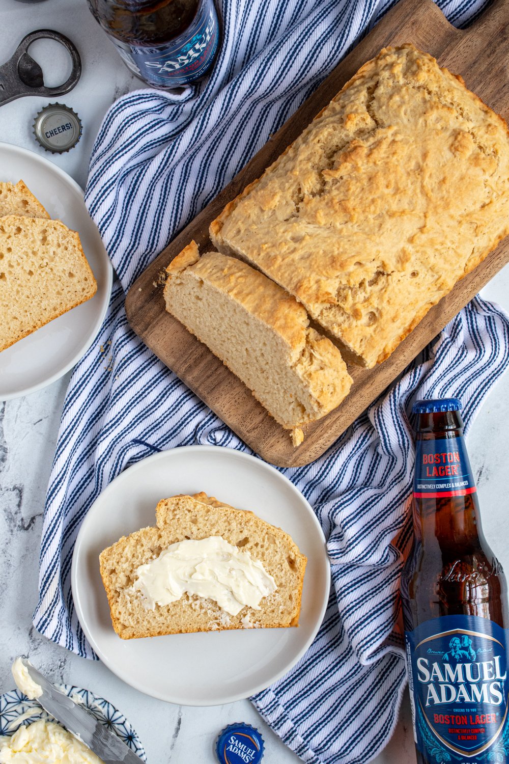 Overhead view of a loaf of easy beer bread with a slice on a plate slathered in butter.