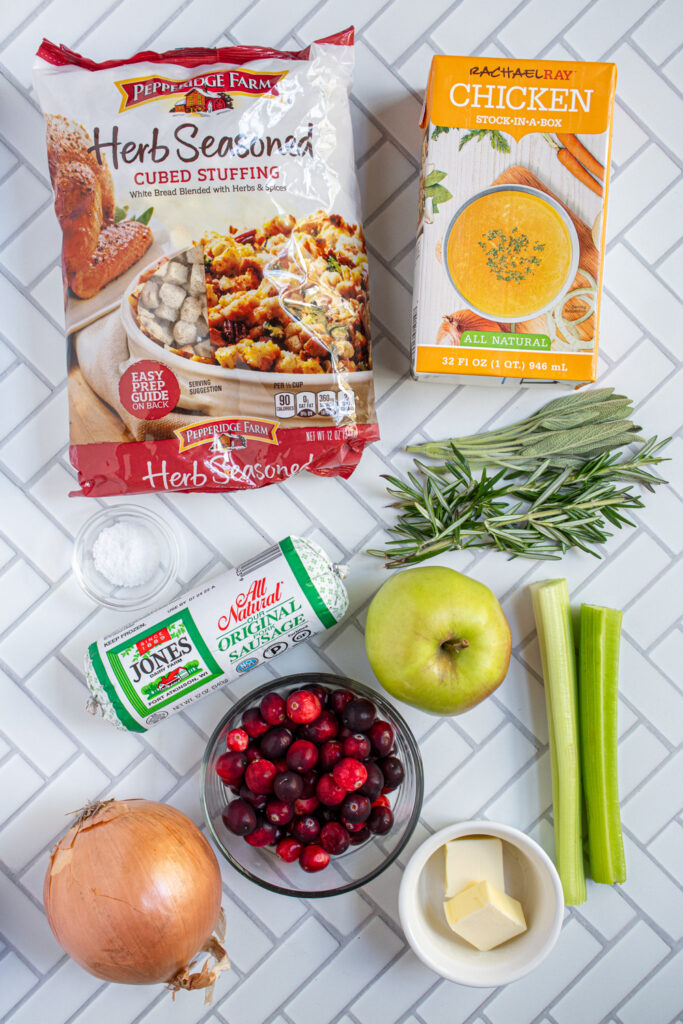 Ingredients needed to make Sausage Cranberry Apple Stuffing laid out on a countertop.