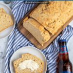 Pinterest Pin with text 'Beer Bread', image of a slice of easy beer bread leaning on a loaf on a cutting board.
