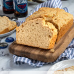 Pinterest Pin with text 'Beer Bread', image of a slice of easy beer bread leaning on a loaf on a cutting board.