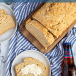 Pinterest Pin with text 'Beer Bread', image of a slice of easy beer bread leaning on a loaf on a cutting board.