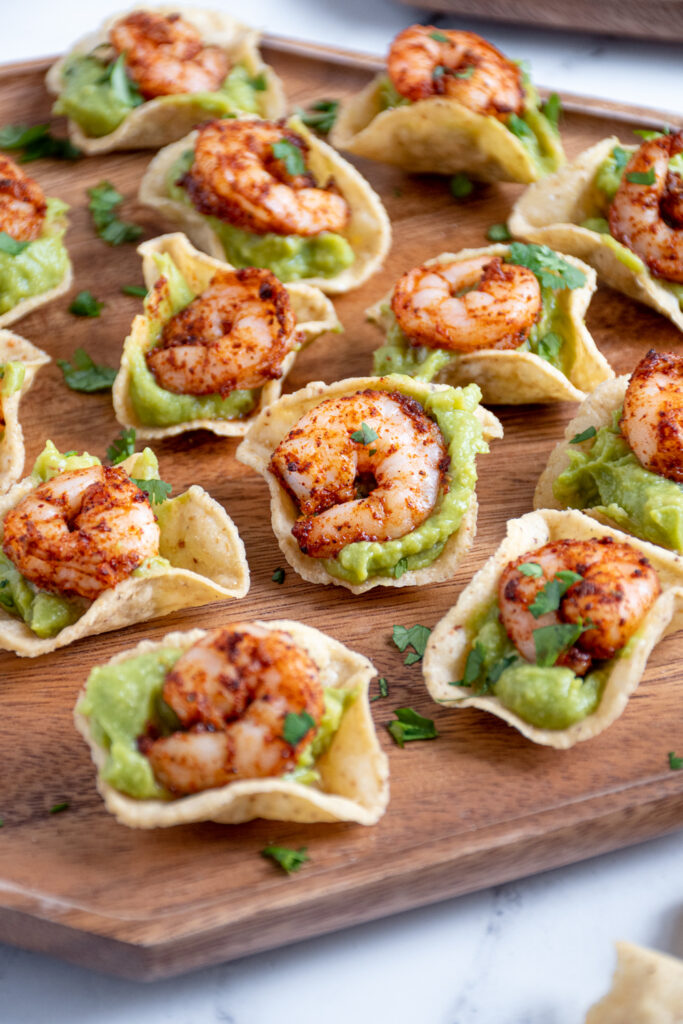 Close up of a shrimp guacamole bite on a platter showing of the juicy taco shrimp on top of guacamole.