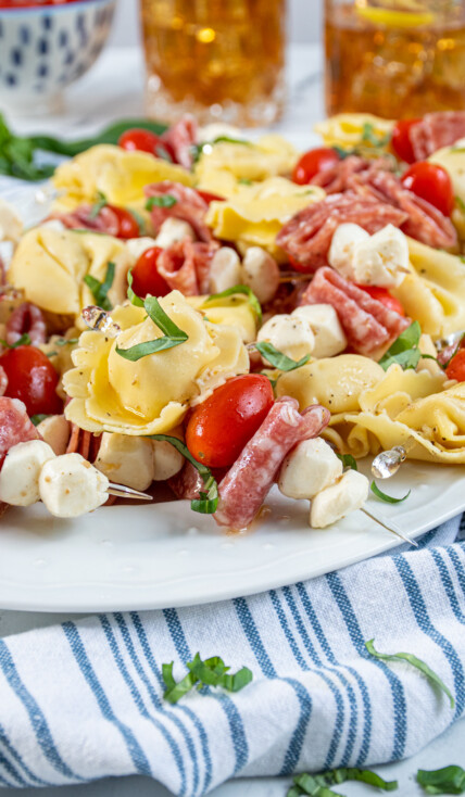 Close up of a single tortellini skewer on a platter full of this delicious and colorful appetizer.