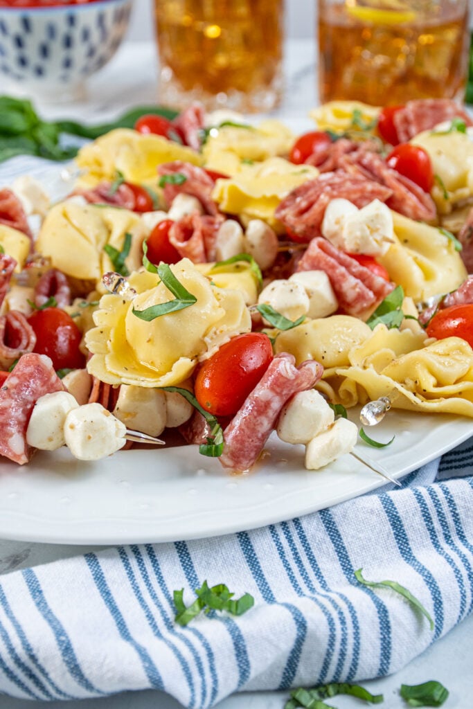 Close up of a single tortellini skewer on a platter full of this delicious and colorful appetizer.