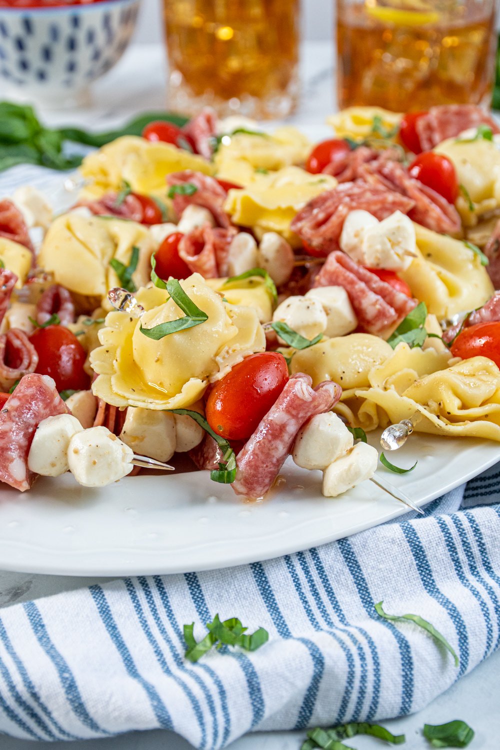 Close up of a single tortellini skewer on a platter full of this delicious and colorful appetizer.