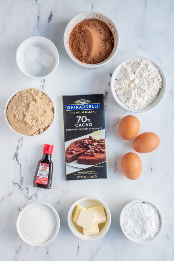 Ingredients needed to make chocolate peppermint crinkle cookies laid out on a table top.