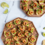 Pinterest Pin with text 'Guacamole Shrimp Bites', image of a wood platter filled with many shrimp guacamole bites.