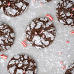 Pinterest Pin with text 'Chocolate Peppermint Crinkle Cookies', image of a bunch of chocolate peppermint crinkle cookies laid out on pice of parchment paper.