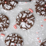 Pinterest Pin with text 'Chocolate Peppermint Crinkle Cookies', image of a bunch of chocolate peppermint crinkle cookies laid out on pice of parchment paper.