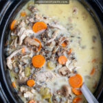 Pinterest Pin with text 'Crockpot Chicken Wild Rice Soup', image of a black crockpot with freshly make soup inside.