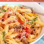 Pinterest Pin with text 'Sausage & Pepper Pasta', image of white bowl filled with penne, bell peppers, and sausage garnished with parmesan cheese.
