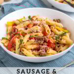 Pinterest Pin with text 'Sausage & Pepper Pasta', image of white bowl filled with penne, bell peppers, and sausage garnished with parmesan cheese.