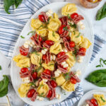 Pinterest Pin with text 'Tortellini Skewer', image of tortellini skewers of a white platter.