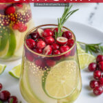Pinterest Pin with text 'White Christmas Sangria', image of stemless wine glasses filled with White Christmas sangria, pears, limes, and cranberries.