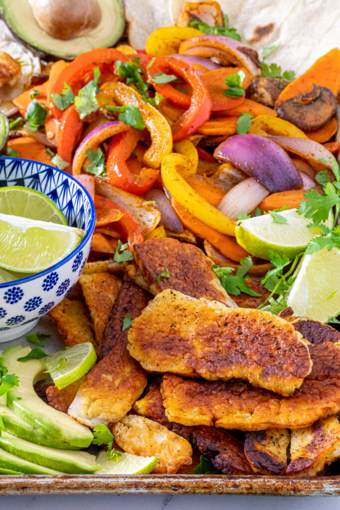 A tray full of the makings of halloumi fajitas including a close up of golden brown fried halloumi.