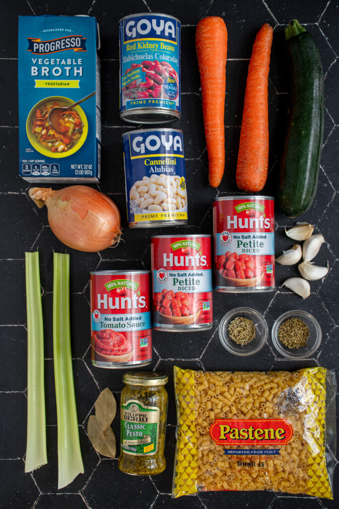 Ingredients laid out on a black table for making minestrone in the slow cooker.