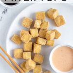Pinterest pin with text 'Crispy Air Fryer Tofu', image of a golden brown pile of tofu on a white plate.