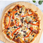 Pinterest pin with text 'Homemade Veggie Pizza', imagine of veggie pizza on a wood pizza peel.