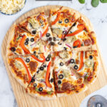 Pinterest pin with text 'Homemade Veggie Pizza', imagine of veggie pizza on a wood pizza peel.
