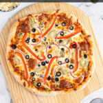 Pinterest pin with text 'Homemade Veggie Pizza', imagine of veggie pizza on a wood pizza peel.