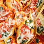 Pinterest pin with text 'Spinach Stuffed Shells without Ricotta', image of sauce and cheesy stuffed shells in a white casserole dish.