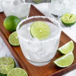 Pinterest Pin with text overlay 'How to make a Classic Margarita', image of a glass with a salted rim filled with a margarita and a lime wheel.