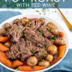 Pinterest Pin with text 'Crockpot Pot Roast', image of a serving bowl with chunks of pot roast, carrots, and baby potatoes.