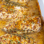 Pinterest Pin with text overlay 'Baked Honey Mustard Chicken Breasts', image of a white casserole dish with four baked chicken breasts with honey mustard sauce.