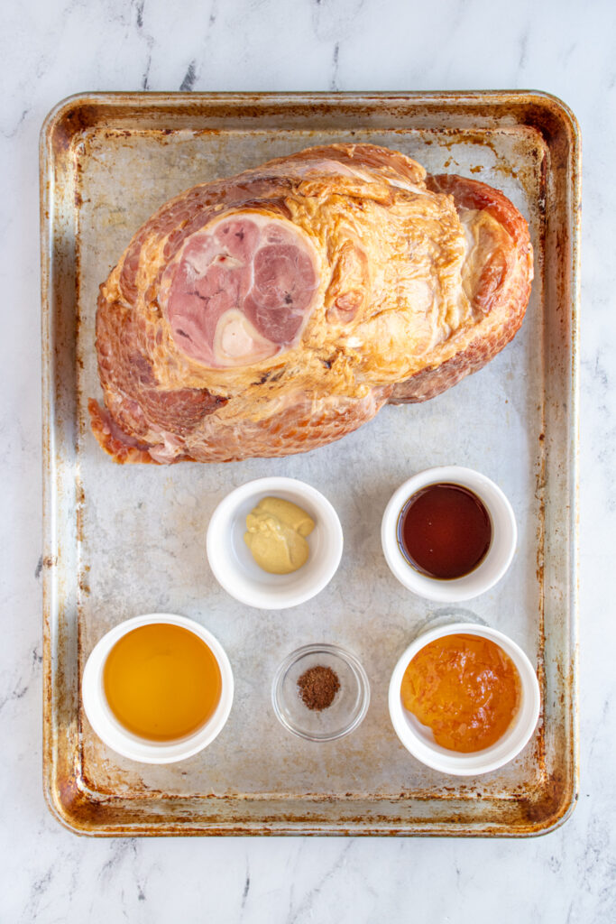 Ingredients for ham with an orange bourbon glaze on a sheet pan.