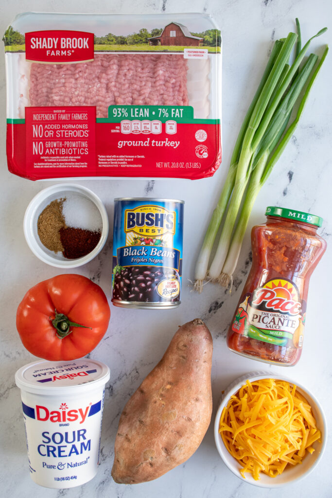 Ingredients needed to make turkey sweet potato skillet laid out on a table top.